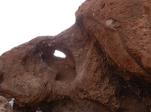 Erosion has caused reddish sandstone to be eroded away, forming caves and even holes.